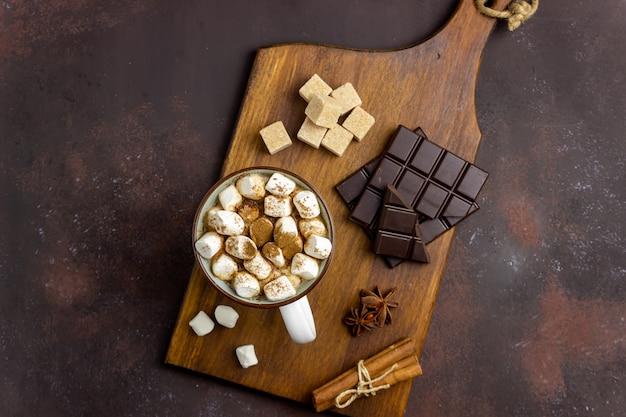 Cioccolata calda con marshmallow in una tazza bianca su uno sfondo arrugginito. Inverno. Ricette.