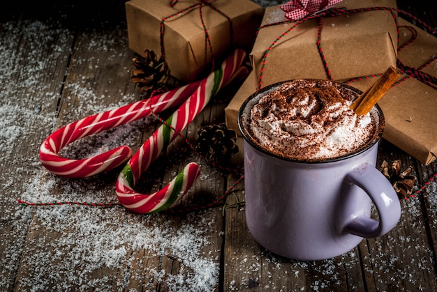 Cioccolata calda con panna montata e spezie, regali di Natale e bastoncini di zucchero