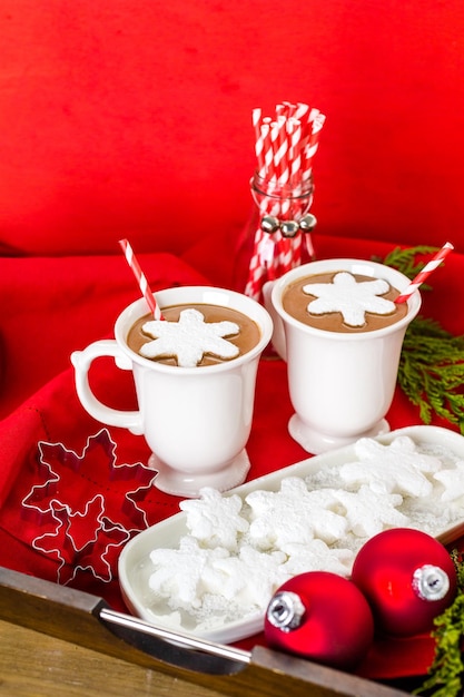 Cioccolata calda fatta in casa guarnita con marshmallow bianchi a forma di fiocco di neve.
