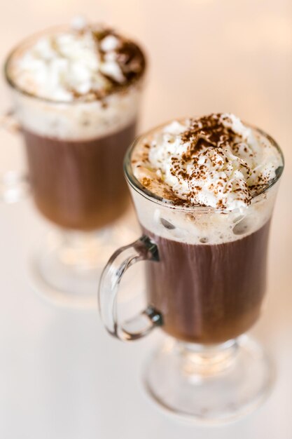 Cioccolata calda guarnita con panna montata e cacao in polvere.