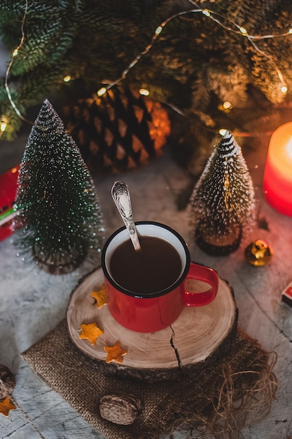 Cioccolata calda in tazza rossa con abeti