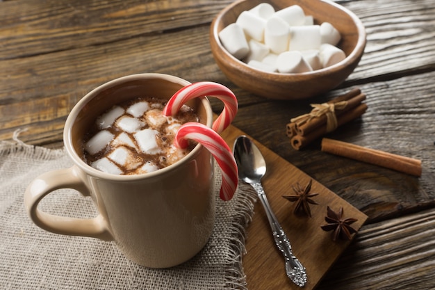 Cioccolata calda, marshmallow e cannella sul tavolo rustico