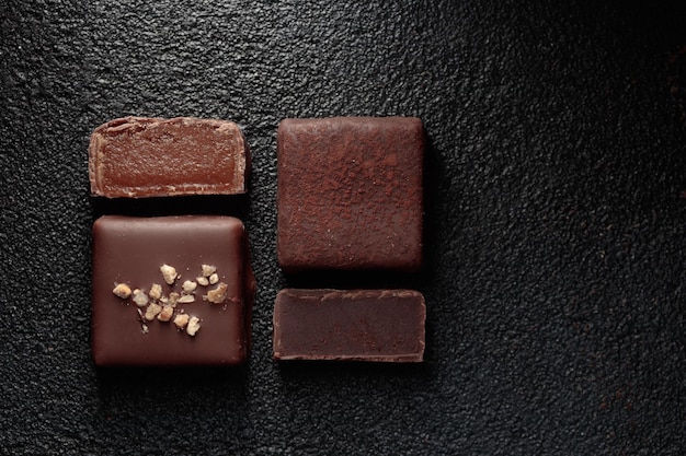 Cioccolatini al cioccolato con caramello e tartufo su sfondo nero