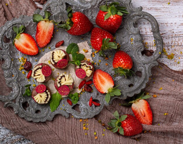 cioccolatini con fragole di marzapane su un vassoio grigio su un tavolo di legno. vista dall'alto