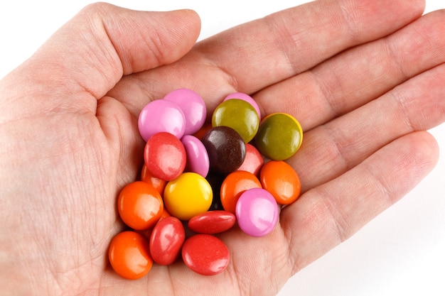 Cioccolatini rotondi colorati o chewing gum in mano