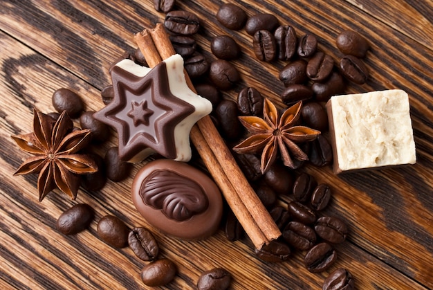 Cioccolato, caffè, cannella e anice su fondo di legno