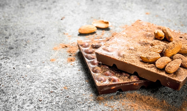 Cioccolato con noci e cacao in polvere sul tavolo rustico.