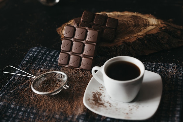 Cioccolato fondente con chicchi di caffè e noci su un tavolo rustico