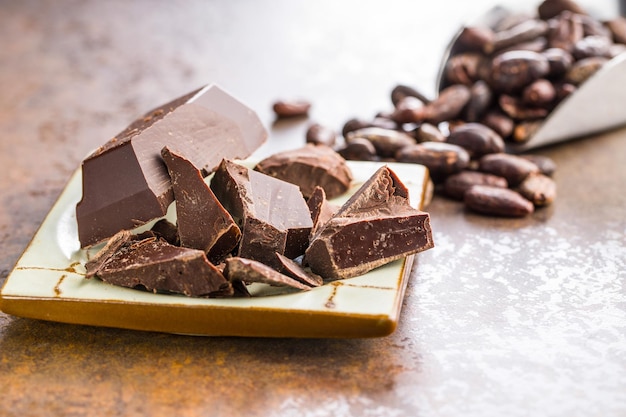 Cioccolato fondente e fave di cacao su fondo arrugginito