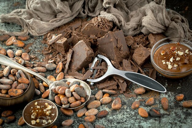 Cioccolato fondente in una composizione con fave di cacao e noci, su un vecchio sfondo.