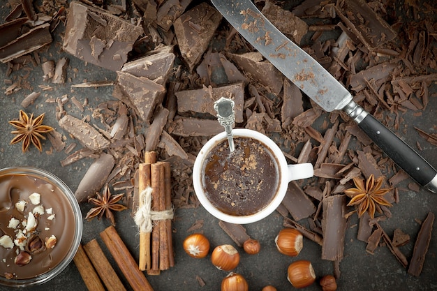 Cioccolato fondente in una composizione con fave di cacao e noci, su un vecchio sfondo.