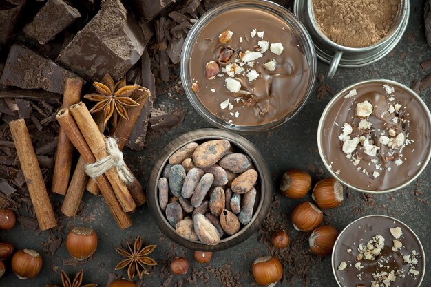 Cioccolato fondente in una composizione con fave di cacao e noci, su un vecchio sfondo.