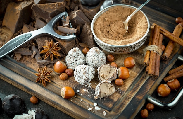 Cioccolato fondente in una composizione con fave di cacao e noci, su un vecchio sfondo.