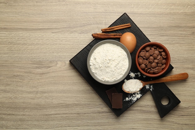 Cioccolato in farina e altri ingredienti per la produzione di pasta su tavolo di legno vista Spazio per il testo
