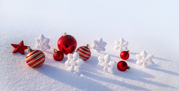 Ciondoli luminosi, palle di Natale, fiocchi di neve e stelle nella neve. decorazioni natalizie