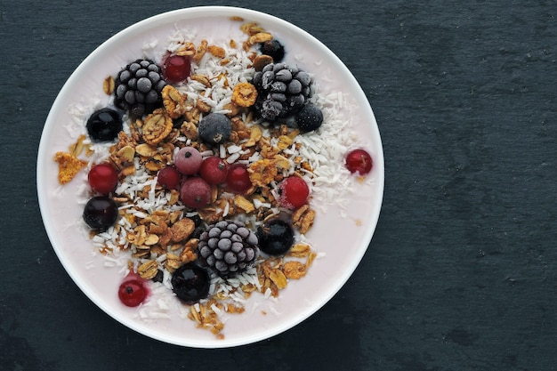 Ciotola bella colazione sana con yogurt, muesli e frutti di bosco.