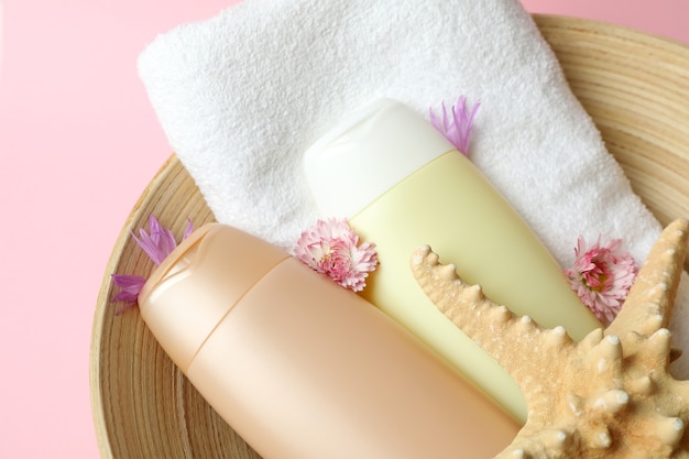 Ciotola con accessori per la cura dei capelli sul rosa