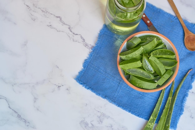 Ciotola con aloe vera a fette su tavola di marmo concetto di cura della pelle Zenithal shot