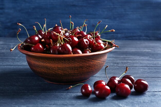 Ciotola con ciliegie dolci fresche sulla tavola di legno