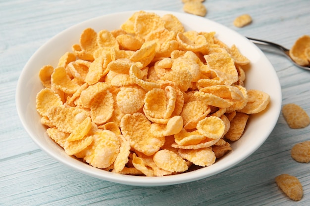 Ciotola con cornflakes su fondo di legno bianco