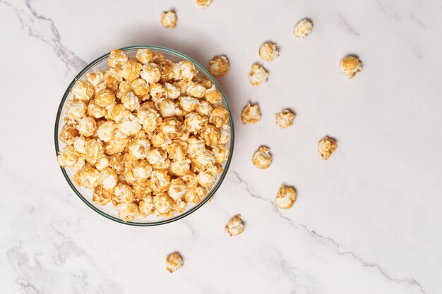 Ciotola con deliziosi popcorn al caramello sul tavolo bianco