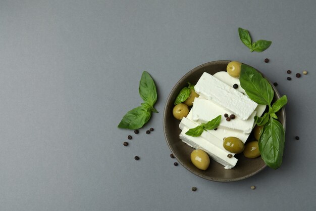 Ciotola con formaggio feta e spezie su superficie grigia