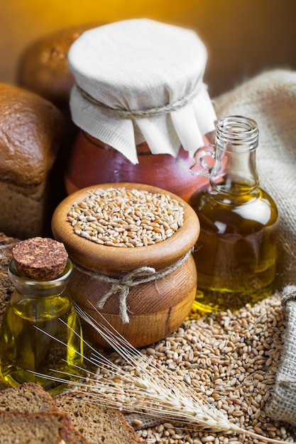 Ciotola con grano e bottiglie di olio