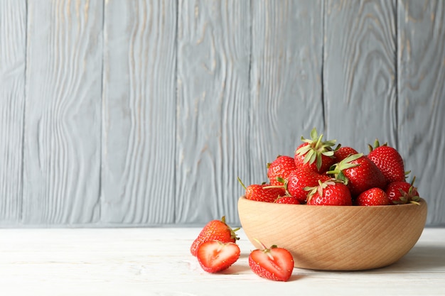 Ciotola con gustosa fragola sul tavolo di legno. Bacca estiva