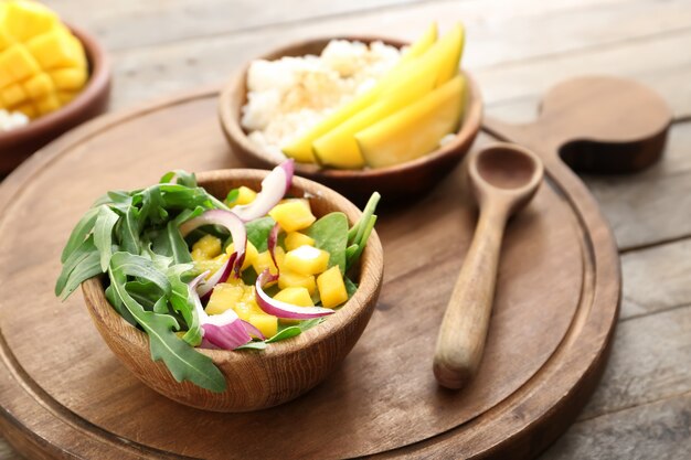 Ciotola con gustosa insalata di mango sulla tavola di legno