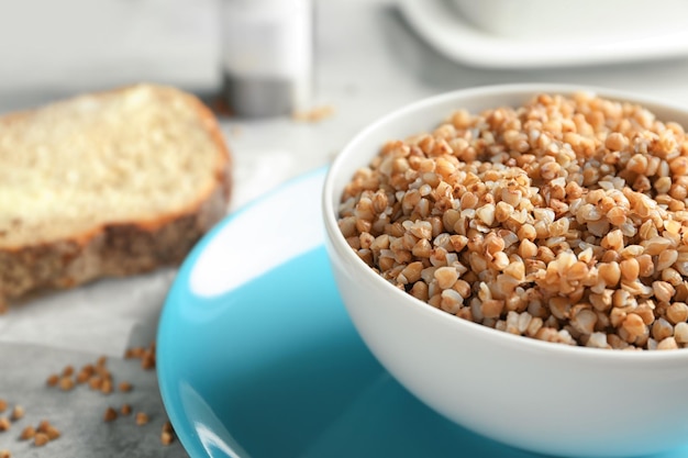 Ciotola con gustoso porridge di grano saraceno sul primo piano della tavola