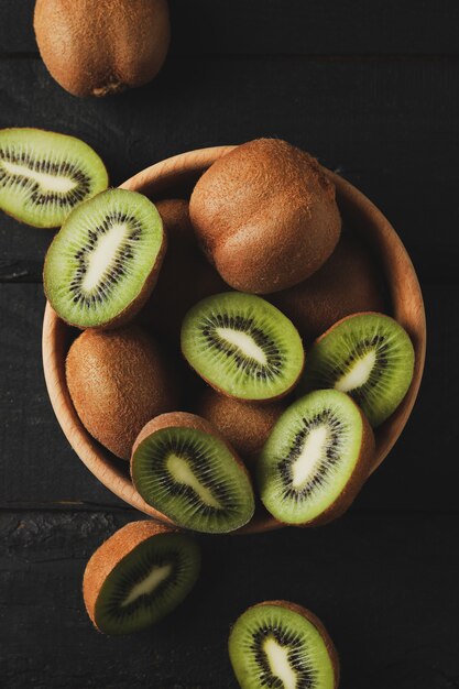 Ciotola con kiwi maturo su superficie di legno