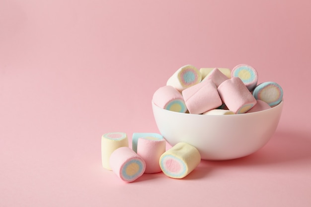 Ciotola con marshmallow sulla superficie rosa