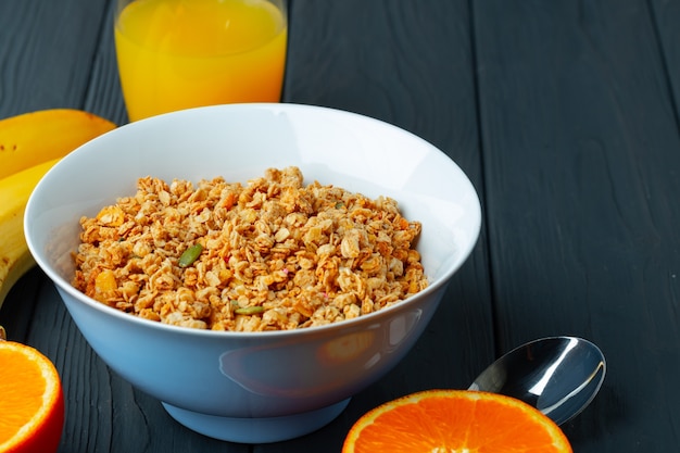 Ciotola con muesli e frutta sul tavolo di legno scuro