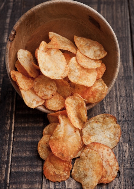 Ciotola con patatine fritte sul bordo di legno