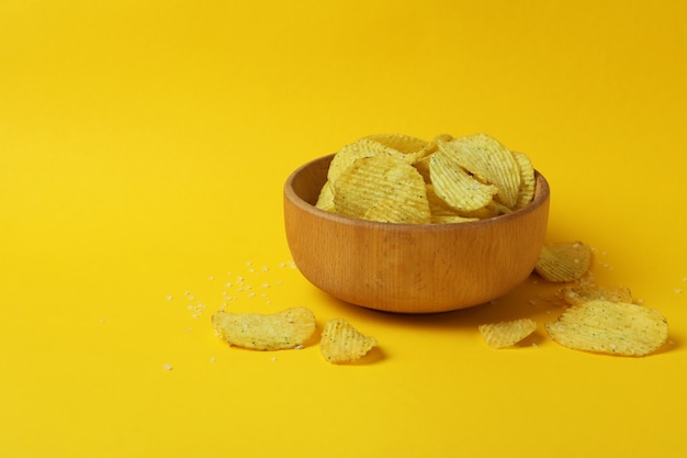 Ciotola con patatine fritte sulla superficie gialla