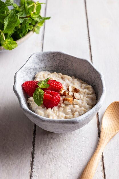 Ciotola con polenta ai cereali decorata con lamponi e menta