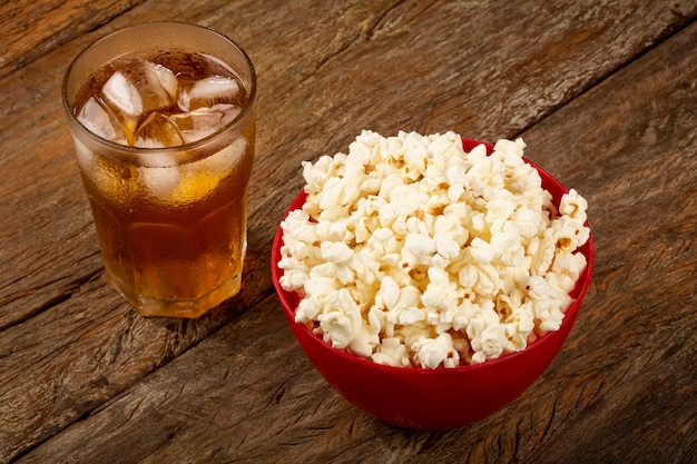 Ciotola con popcorn salati e soda sul tavolo