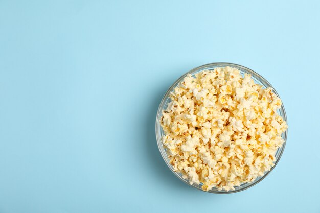 Ciotola con popcorn sull'azzurro. Cibo per guardare il cinema