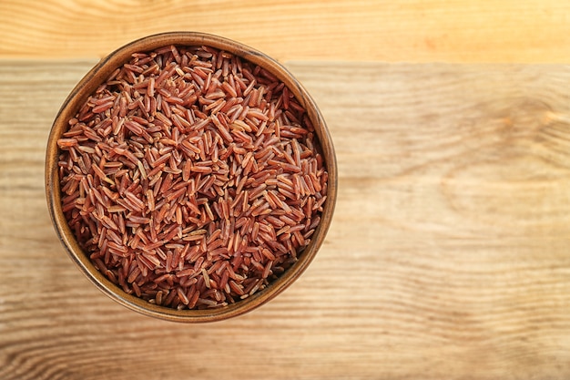 Ciotola con riso crudo sulla tavola di legno