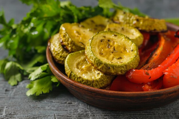 Ciotola con zucchine al forno e pepe con erbe aromatiche sul tavolo