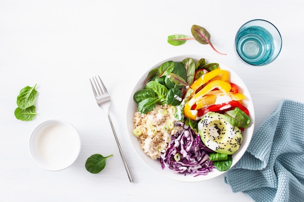 Ciotola da pranzo di couscous vegetariano con avocado, peperoni, spinaci e cavolo rosso