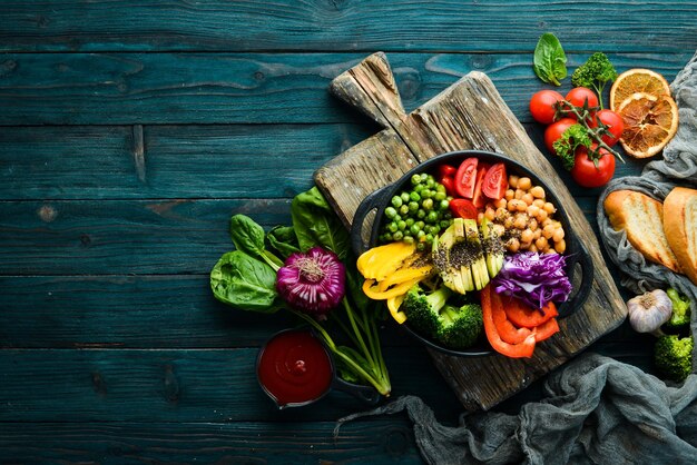 Ciotola del Buddha ceci avocado broccoli paprika piselli pomodori Insalata di verdure Vista dall'alto Spazio libero per il testo