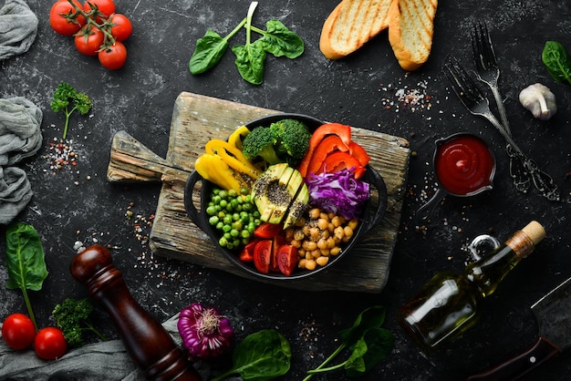 Ciotola del Buddha ceci avocado broccoli paprika piselli pomodori Insalata di verdure Vista dall'alto Spazio libero per il testo