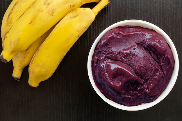 Ciotola di acai e banane su un tavolo nero