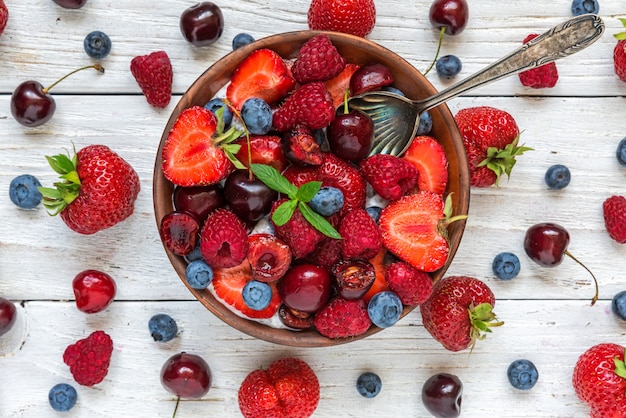 Ciotola di bacche estive con yogurt o budino di chia con lamponi freschi, fragole e mirtilli con un cucchiaio