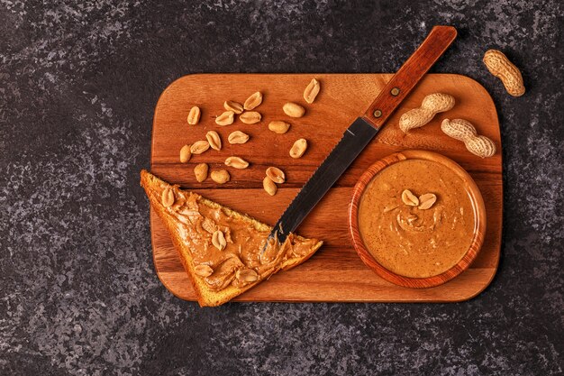Ciotola di burro di arachidi su tavola di legno