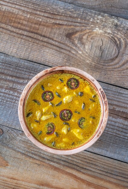 Ciotola di curry di funghi gialli sul tavolo di legno