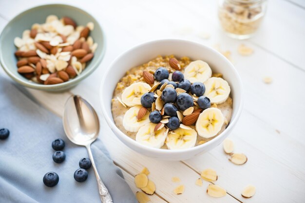 Ciotola di farina d'avena con fette di banana, mirtilli e scaglie di mandorle