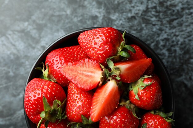 Ciotola di fragole fresche su superficie nera affumicata