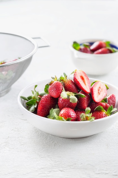 Ciotola di fragole fresche sulla tavola bianca